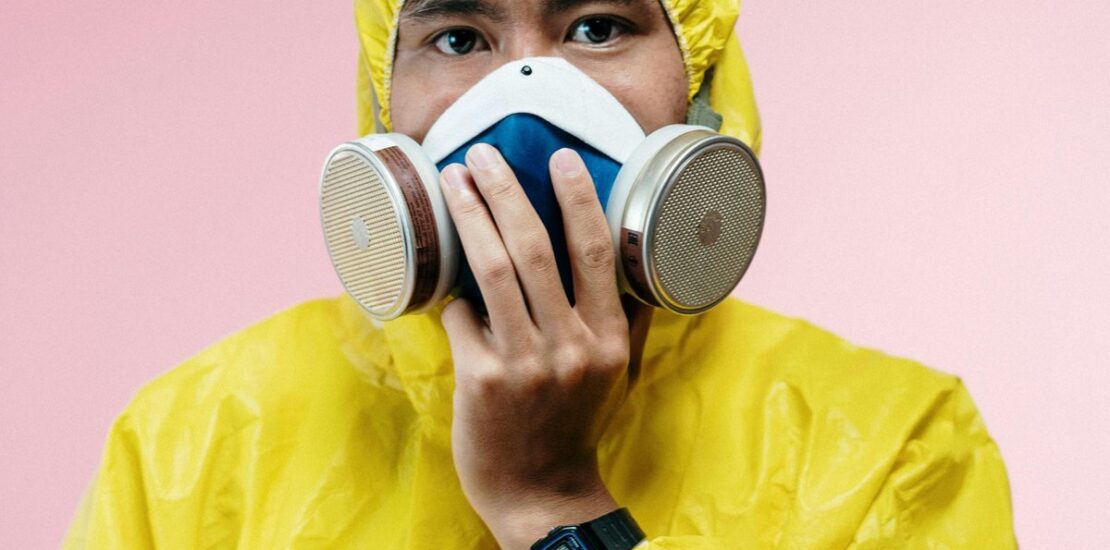 Technician in yellow hazmat suit and respirator during mold remediation